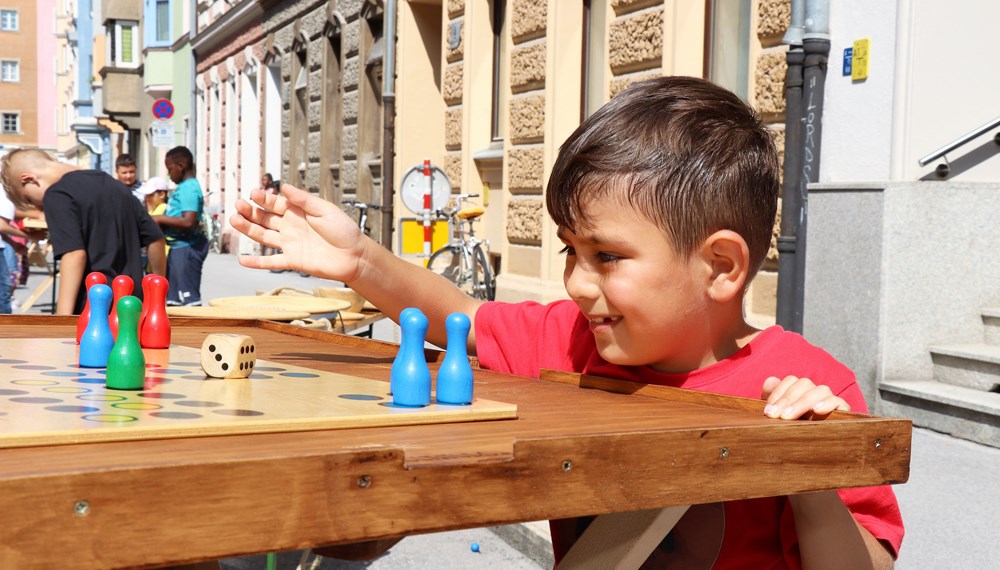 Am 1. Juli begrüßten die SchülerInnen der Volksschule Franz-Fischer-Straße Bürgermeister Georg Willi bei ihrem Sommerfest mit Spielen aus alter Zeit. Nicht nur die Kinder, auch der Bürgermeister waren trotz Hitze mit Feuereifer bei der Sache.