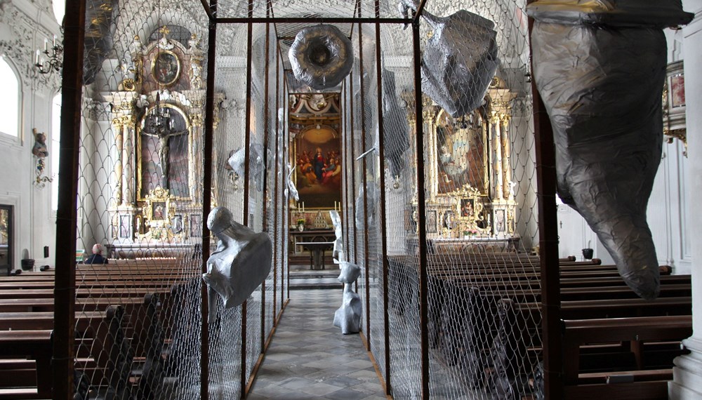 Ein Kunstwerk holt das aktuelle weltpolitische Geschehen nach Innsbruck: Bis Ende September sind vor und in der Innsbrucker Spitalskirche Objekte des Tiroler Künstlers Alois Schild zu sehen. Die Kunstinstallation ist eine Anspielung auf den von US-Präsident Donald Trump in Auftrag gegebenen Mauerbau an der Grenze zu Mexiko und macht einerseits die Abschottungspolitik gegenüber Menschen auf der Flucht und die Radikalisierung der Gesellschaft zum Thema, hält zugleich aber die Hoffnung auf die Überwindung von Spaltung und Ausgrenzung aufrecht.
Auf den Mauerbau, der in den Köpfen vieler Menschen auch in Europa vor sich gehe, weist Bürgermeister Georg Willi hin. „Wir übersehen dabei, wie sehr dieser neue Mauerbau an den Grundsätzen der Demokratie, an der Europäischen Friedensordnung und an den Menschenrechten rüttelt“, so Willi: „Diese Mauern trennen, sie spalten uns aber auch im Inneren und wir verlernen, Brücken zu bauen und aufeinander zuzugehen.“ Neben der Kunst sei es immer wieder auch die Kirche, die daran erinnere, „Brücken und nicht Mauern zu bauen“, so der Bürgermeister. Mehr Informationen zur Ausstellung unter www.dibk.at/Meldungen/Von-der-Mauer-zum-Korridor