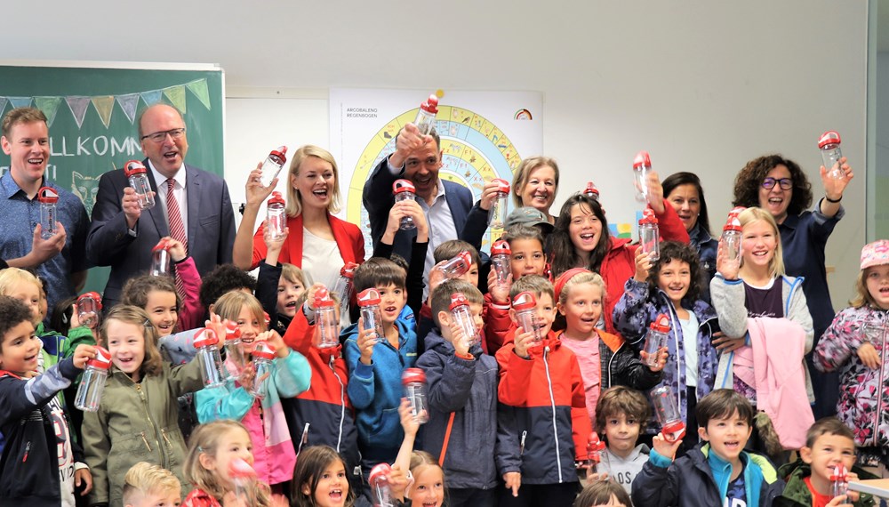 Pünktlich zum Schulstart verschenkt die IKB AG rund 1.100 wiederverwendbare Wasserflaschen an Innsbrucks ErstklässlerInnen. Bürgermeister Georg Willi, Stadträtin Elisabeth Mayr und IKB-Vorstandsvorsitzender Helmuth Müller besuchten stellvertretend für alle Innsbrucker Volksschulen die Volksschule Innere Stadt. Gespannt lauschten die Kinder der Geschichte von Innsbrucks frischem Quellwasser und ließen sich zeigen, wie man die Trinkflaschen auslaufsicher in den Schulrucksäcken verstauen kann.