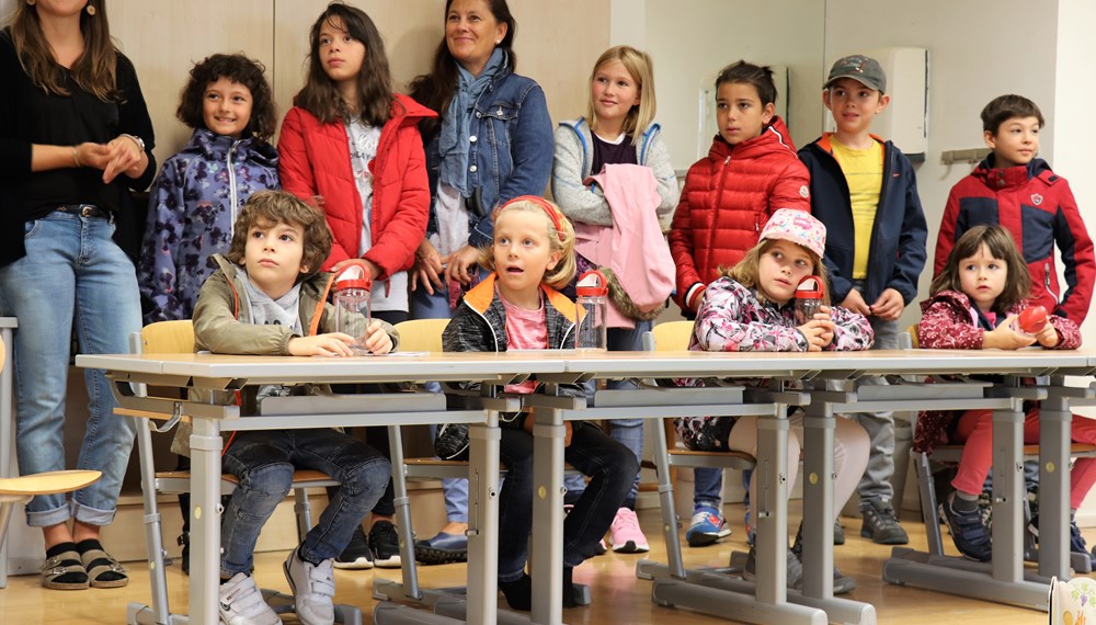 Pünktlich zum Schulstart verschenkt die IKB AG rund 1.100 wiederverwendbare Wasserflaschen an Innsbrucks ErstklässlerInnen. Bürgermeister Georg Willi, Stadträtin Elisabeth Mayr und IKB-Vorstandsvorsitzender Helmuth Müller besuchten stellvertretend für alle Innsbrucker Volksschulen die Volksschule Innere Stadt. Gespannt lauschten die Kinder der Geschichte von Innsbrucks frischem Quellwasser und ließen sich zeigen, wie man die Trinkflaschen auslaufsicher in den Schulrucksäcken verstauen kann.