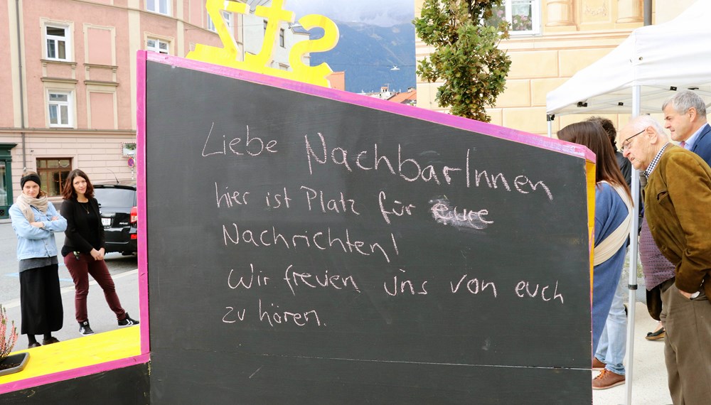 Kreativ, bunt und unübersehbar – so präsentiert sich seit 4. Oktober das temporäre, öffentliche Möbelstück vor dem Stadtteilzentrum Wilten in der Leopoldstraße 33a. Die Idee für das hölzerne Bauwerk entstand im Rahmen eines Beteiligungsprozesses bereits im Dezember 2017. Damals kamen NachbarInnen, ein Kreativteam aus Wilten und VertreterInnen des Stadtteilzentrums zusammen, um über die Gestaltung des Innenhofes zu beratschlagen. Die nun realisierte Konstruktion enthält die gewünschten Elemente, bestehend aus Beschriftung, Informations- und Plakatflächen, einem Buchtauschregal, Sitzgelegenheiten und kann mit Blumentöpfen ausgestattet werden. Bei der Einweihung kamen viele Beteiligte und UnterstützerInnen zusammen, unter ihnen auch Gemeinderätin Janine Bex, Geschäftsführer Hubert Innerebner (Innsbrucker Sozialen Dienste, ISD), Stadtteilkoordinatorin Florence Fritz sowie das Kreativteam rund um Charly Walter und zahlreiche AnrainerInnen. Bis Juni 2021 lädt das öffentliche Möbelstück vor dem Stadtteilzentrum Wilten zum Verweilen und Verwenden ein. AA