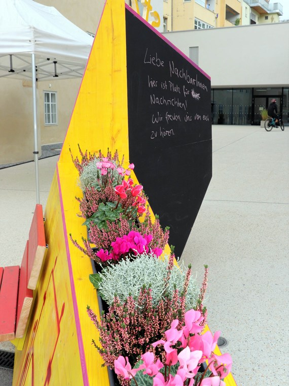 Kreativ, bunt und unübersehbar – so präsentiert sich seit 4. Oktober das temporäre, öffentliche Möbelstück vor dem Stadtteilzentrum Wilten in der Leopoldstraße 33a. Die Idee für das hölzerne Bauwerk entstand im Rahmen eines Beteiligungsprozesses bereits im Dezember 2017. Damals kamen NachbarInnen, ein Kreativteam aus Wilten und VertreterInnen des Stadtteilzentrums zusammen, um über die Gestaltung des Innenhofes zu beratschlagen. Die nun realisierte Konstruktion enthält die gewünschten Elemente, bestehend aus Beschriftung, Informations- und Plakatflächen, einem Buchtauschregal, Sitzgelegenheiten und kann mit Blumentöpfen ausgestattet werden. Bei der Einweihung kamen viele Beteiligte und UnterstützerInnen zusammen, unter ihnen auch Gemeinderätin Janine Bex, Geschäftsführer Hubert Innerebner (Innsbrucker Sozialen Dienste, ISD), Stadtteilkoordinatorin Florence Fritz sowie das Kreativteam rund um Charly Walter und zahlreiche AnrainerInnen. Bis Juni 2021 lädt das öffentliche Möbelstück vor dem Stadtteilzentrum Wilten zum Verweilen und Verwenden ein. AA