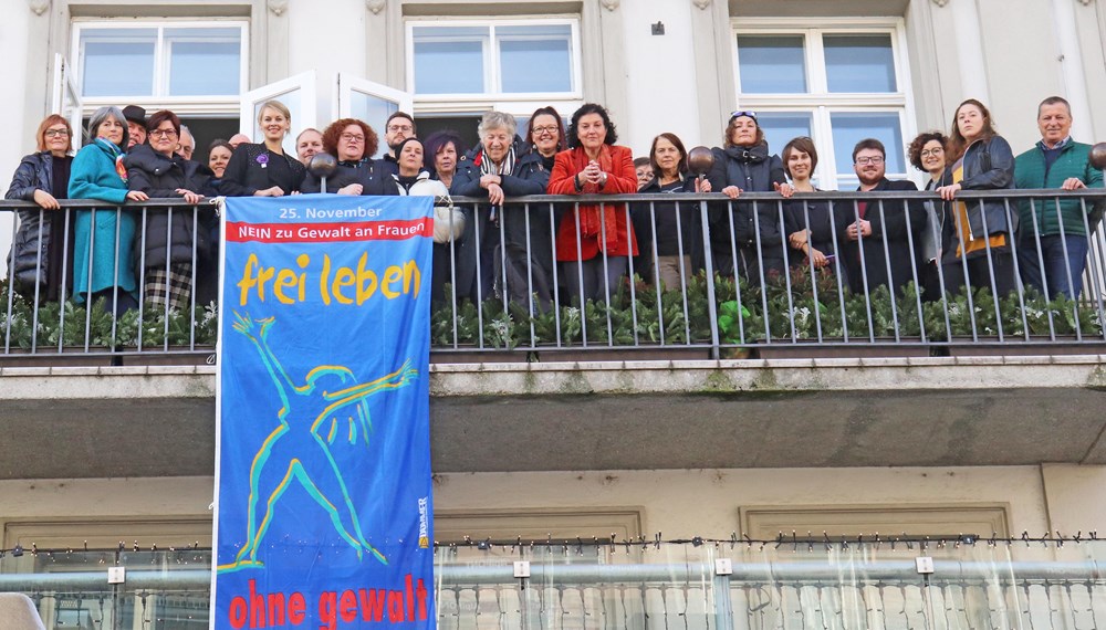 Frauenstadträtin Elisabeth Mayr (vorne, 4. v. l.) und Referatsleiterin Uschi Klee (12. v. r.) hissten gemeinsam mit VertreterInnen der Stadtpolitik, den MitarbeiterInnen der Stadtverwaltung sowie VertreterInnen der Innsbrucker Frauenorganisationen die „Frei leben ohne Gewalt“ am Balkon des Rathauses in der Maria-Theresien-Straße.