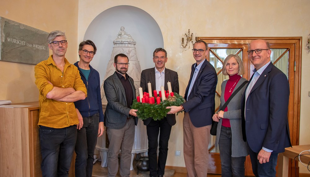 Die diakonischer Organisationen in Tirol überreichten als Dankeschön Bürgermeister Georg Willi einen „Wichern-Adventkranz“. Dabei nützten die Vertreter der Sozialorganisationen die Gelegenheit, ihre Arbeit in kurzen Worten vorzustellen und ihre Anliegen an die Stadt Innsbruck zum Ausdruck zu bringen. Die Diakonie möchte mit dieser kleinen vorweihnachtlichen Geste für die tatkräftige Unterstützung ihrer Arbeit danken. Der Adventkranz ist eng mit den Wurzeln der Diakonie verbunden. Um Kindern aus ärmsten Verhältnissen die Zeit bis Weihnachten zu verkürzen, entzündete der Gründer der Diakonie Johann Hinrich Wichern im "Rauhen Haus" der Diakonie 1839 in Hamburg jeden Tag eine Kerze an einem Wagenrad, das er mit 19 kleinen roten und vier großen Kerzen geschmückt hatte. Aus dieser Idee entstand der uns heute bekannte Adventkranz. (v.l.) Michael Kerber (Diakonie Flüchtlingsdienst, Leitung und Rechtsberatung), Werner Geißelbrecht (Pfarrer Christuskirche Saggen), Stephan Mader (Diakoniewerk Soziale Dienstleistung GmbH, Bereichsleitung Tirol), Bürgermeister Georg Willi, Olivier Dantine (Superintendent der evangelischen Kirche für die Diözese Salzburg-Tirol), Renate Gabriel (Diakonischer Verein Tirol, StudentInnen-Wohnheim Saggen) und Franz Bittersam (Geschäftsführer Johanniter Tirol).