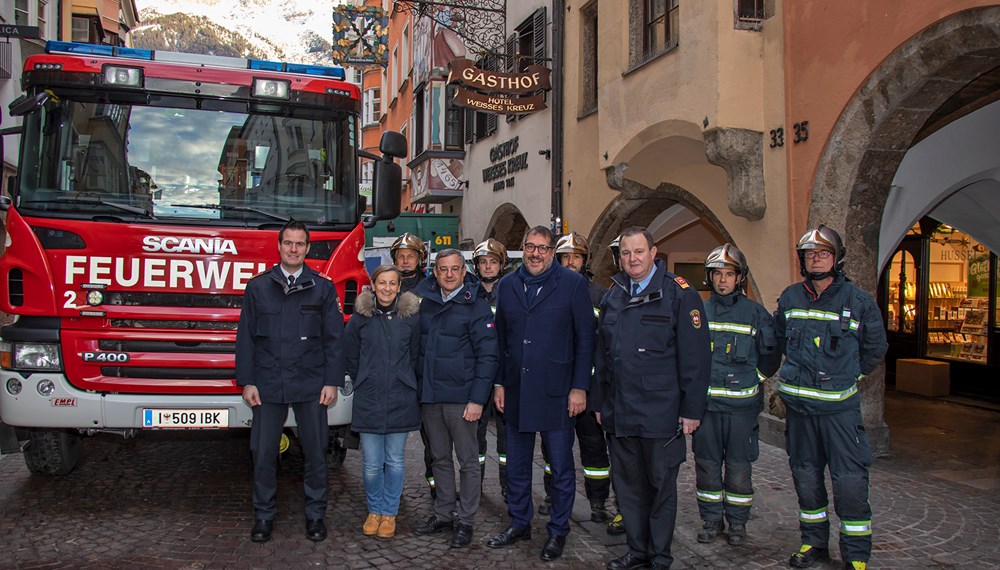Vizebürgermeister Franz X. Gruber (Bildmitte), gemeinsam mit Branddirektor Helmut Hager (l.), Branddirektor-Stellvertreter Johann Zimmermann (3. v. r.), den Hotelbesitzern Brigitte Tschoner (2. v. l.) und Thomas Hudovernik (4. v. l.) sowie eine Mannschaft der Berufsfeuerwehr vor dem altehrwürdigen Hotel Weißes Kreuz in der Altstadt.