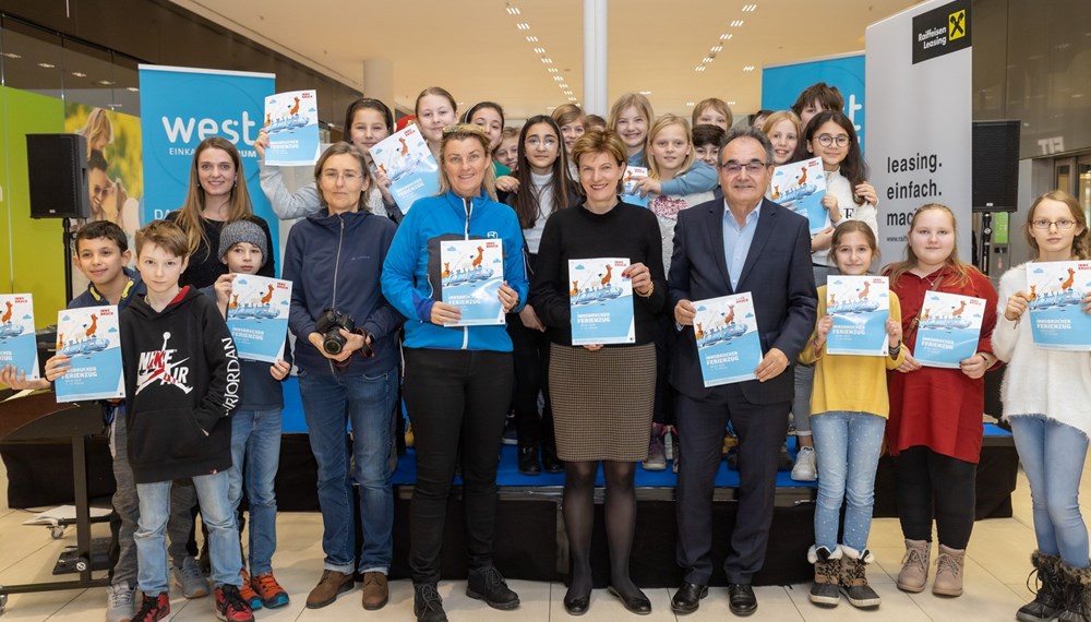 Mit einem großen Familienfest fand im Einkaufszentrum "west" in der Höttinger Au zum fünften Mal der offizielle Auftakt für den Semester-Ferienzug der Stadt Innsbruck statt. Die SchülerInnen des BRG in der Au sorgten am Vormittag mit einer musikalischen Darbietung für einen schwungvollen Startschuss. Im Anschluss läuteten Stadträtin Christine Oppitz-Plörer (Bildmitte), Monika Dlaska vom BRG (4.v.l.), Ferienzug-"Mama" Birgit Ginter (5.v.l.) sowie Karl Weingrill, "west"-Center-Manager und Eigentümervertreter der Raiffeisen-Leasing (4.v.r.), den Semester-Ferienzug 2020 offiziell ein.