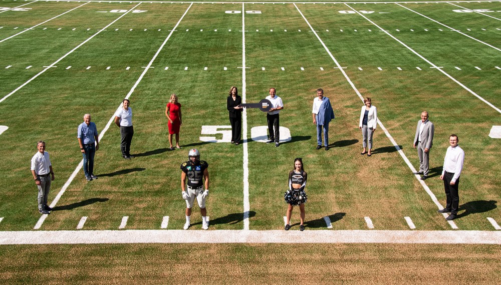 Bei der Schlüsselübergabe für das neue Football-Zentrum: OSVI-Prokurist Christoph Kaufmann, OSVI-GF Matthias Schipflinger, IIG-GF Franz Danler, StRin Elisabeth Mayr, Raiders-Präsidentin Elisabeth Swarovski, LHStv. Josef Geisler, BM Georg Willi, StRin Christine Oppitz-Plörer, Vorsitzender Christian Girardi (OSVI-Aufsichtsrat) und AFCVT-Präsident Gerwin Wichmann (v.l.) gemeinsam mit Raiders-Spieler Tobias Bonatti und Cheerleaderin Lea Deutsch.