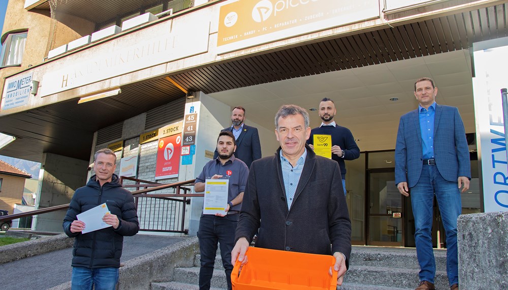 Die BewohnerInnen im Olympischen Dorf haben in ihrem Stadtteil wieder eine Poststelle. Der Handyshop PICCUS hat kürzlich eine Filiale in der Schützenstraße 41 gegenüber der Polizeiinspektion Neu-Arzl eröffnet und wird dort eben auch Postpartner-Dienste anbieten. Die beiden Geschäftsführer Alkim Isik (2. v. l.) und Emre Günal (Mitte oben) freuen sich gemeinsam mit Bürgermeister Georg Willi, Gemeinderat und Präsident des ortsansässigen Verbandes Neu-Arzl/Olympisches Dorf (VNO) Christoph Kaufmann (1. v. l.) sowie Gerhard Hainz (Verkaufsleiter Tirol, Österreichische Post AG, oben links) und Thomas Bramberger (Change-Management Mitte West, Österreichische Post AG, oben rechts) über die Inbetriebnahme des Postpartner-Shops.