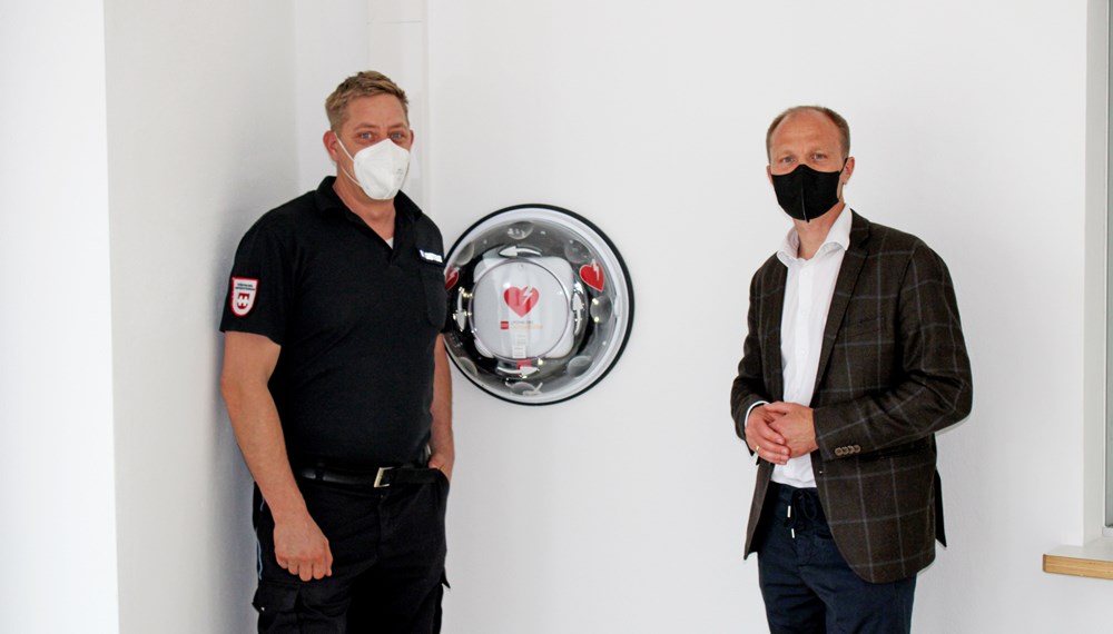 Vizebürgermeister Anzengruber (r.) und MÜG-Mitarbeiter Thomas Hintersdorf vor dem neu angebrachten Defibrillator.