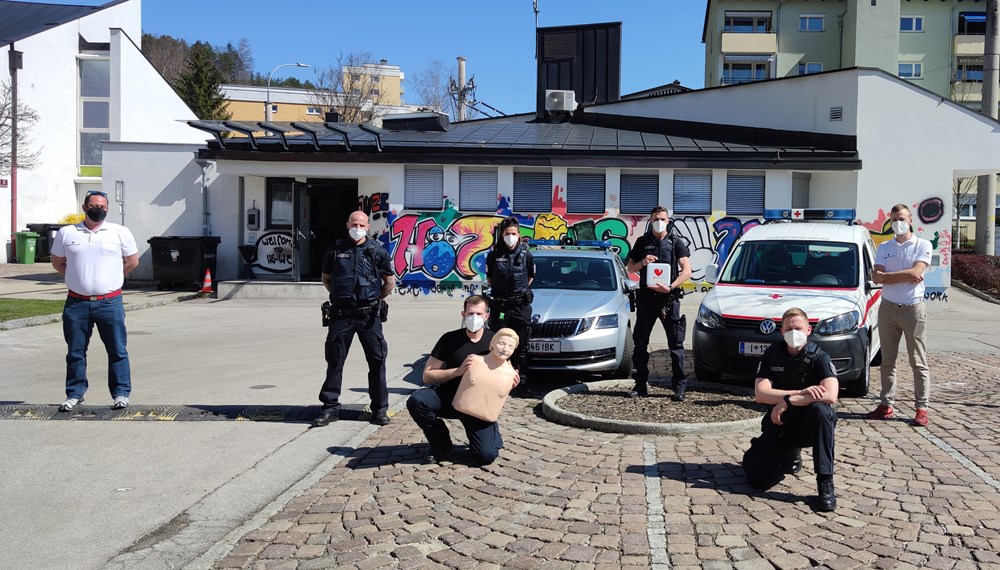Die MitarbeiterInnen der Mobilen Überwachungsgruppe und des Roten Kreuzes mit dem Defibrillator vor der MÜG-Außenstelle Hötting West.