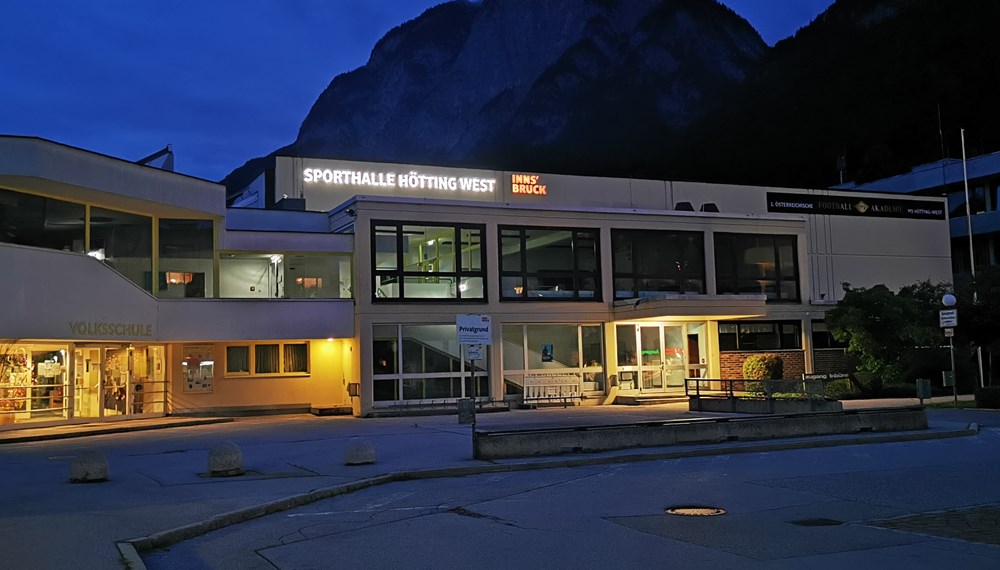Der neue Schriftzug leuchtet an der Sporthalle Hötting-West ist besonders in den Abendstunden gut erkennbar.