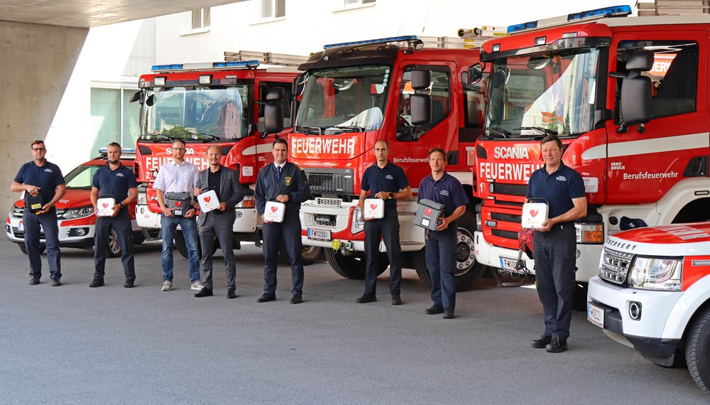 Freuen sich über die zusätzliche lebensrettende Ausstattung der Einsatzfahrzeuge (v.l.n.r.): Hauptbrandmeister Martin Walch, Brandmeister Markus Klaus, Leiter des Ausbildungszentrums Rotes Kreuz Matthias Stark, Vizebürgermeister Johannes Anzengruber, Branddirektor Helmut Hager, Oberbrandmeister Martin Tiefnig, Brandmeister Florian Degasper, Oberbrandmeister Gerhard Pernlochner