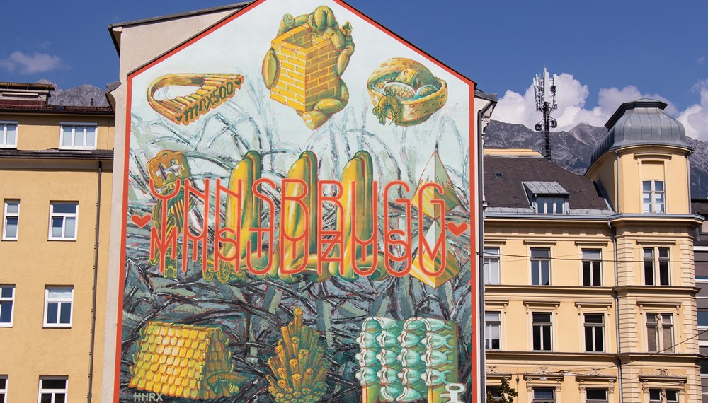 Neben Graffiti auf städtischen Freiflächen finden sich auch Auftragsarbeiten. Das Wandbild in der Maximilianstraße 9 (siehe Bild) stammt vom international bekannten, Innsbrucker Künstler HNRX.