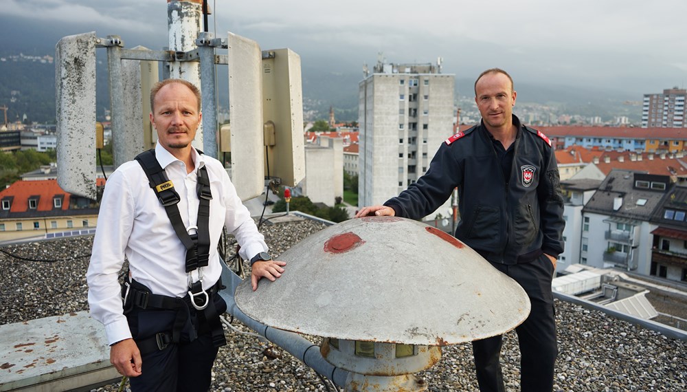 Vizebürgermeister Johannes Anzengruber und Roland Alessandri von der Berufsfeuerwehr inspizieren die Sirene am Dach der Hauptfeuerwache in Pradl.