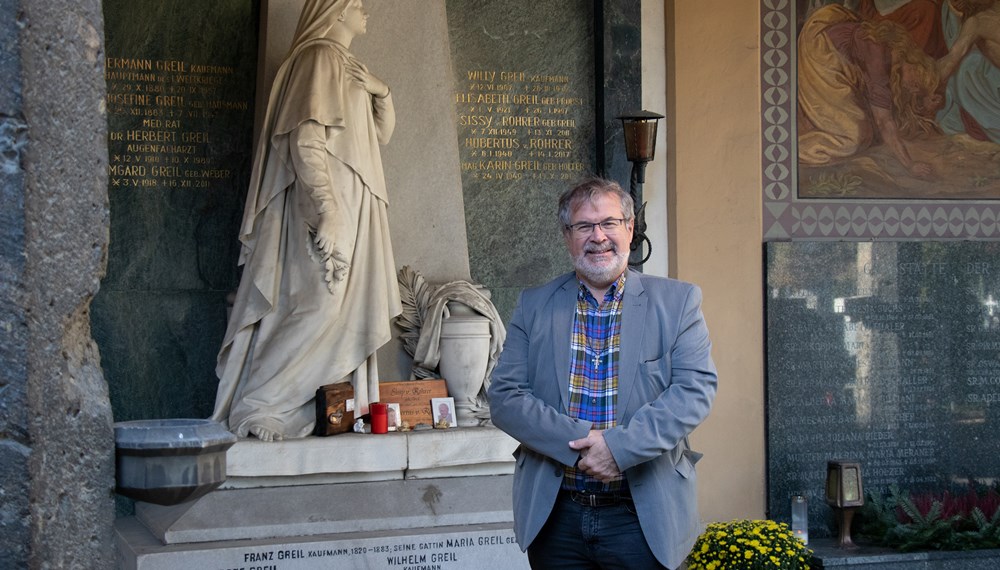Herr über Innsbrucks Friedhöfe: Alexander Legniti vor dem Grabmal von Wilhelm Greil am Westfriedhof.
