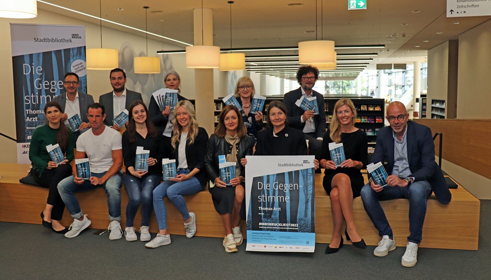 2022 heißt es erstmals „Innsbruck liest und hört“: Kulturstadträtin Uschi Schwarzl (vorne, 3. v.r.), die Leiterin der Stadtbibliothek Innsbruck, Christina Krenmayr (hinten, 3. v.l.) und Landesrätin Beate Palfrader (hinten, 2. v.r.) mit weiteren SponsorInnen präsentieren die Aktion „Innsbruck liest 2022“.