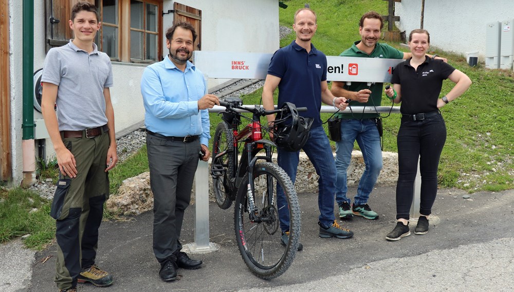 Florian Jäger (Referatsleiter Wald und Almen), Roland Tiwald (IKB-Geschäftsbereichsleiter Strom-Netz), Vizebürgermeister Johannes Anzengruber und das Pächterpaar Alexander Hulak und Christina Meilinger (v.r.n.l.) freuen sich über die neue E-Ladestation für E-Bikes.