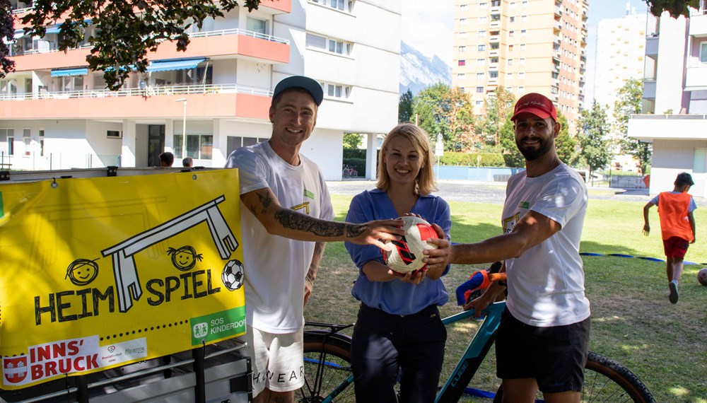 Stadträtin Elisabeth Mayr freut sich mit den zwei Sportpädagogen des SOS-Kinderdorf Dennis Höpfel (1.v.l) und Asad Zaki (3.v.l) über die zahlreichen Kinder, die das Sportangebot des „Heimspiel“-Projektes mit großer Freude nutzen.