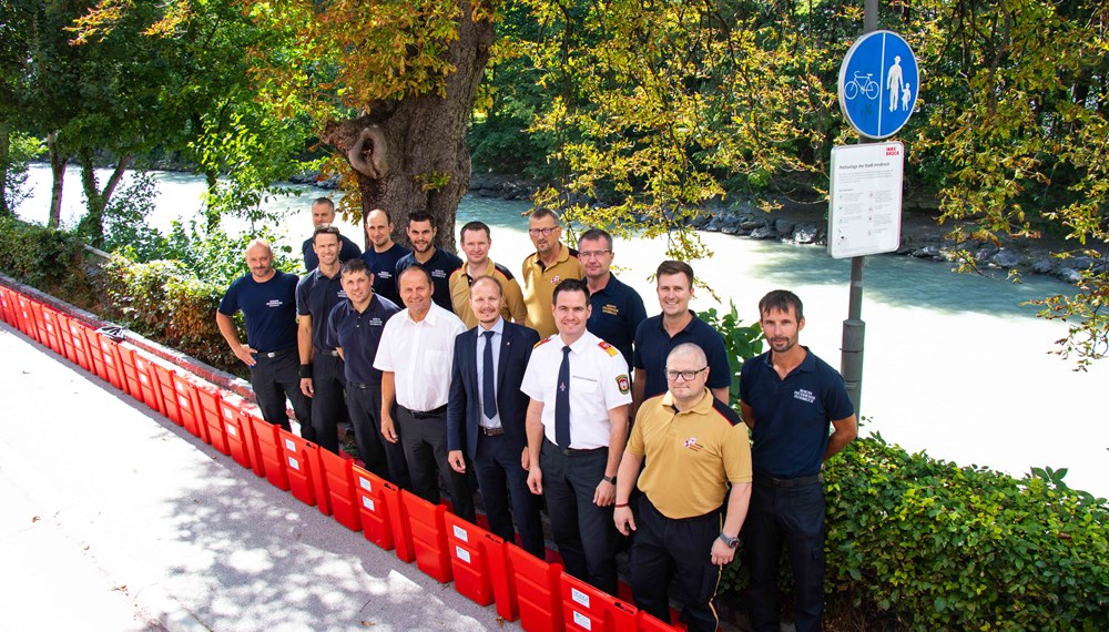 Beim Lokalaugenschein der neuen Hochwasserschutzelemente: LH-Stv. Josef Geisler (vorne, 4.v.l), Vizebürgermeister Johannes Anzengruber (vorne, 3.v.r) und Branddirektor Helmut Hager (vorne, 2.v.r) mit Männern der Freiwilligen- und Berufsfeuerwehr Innsbruck.