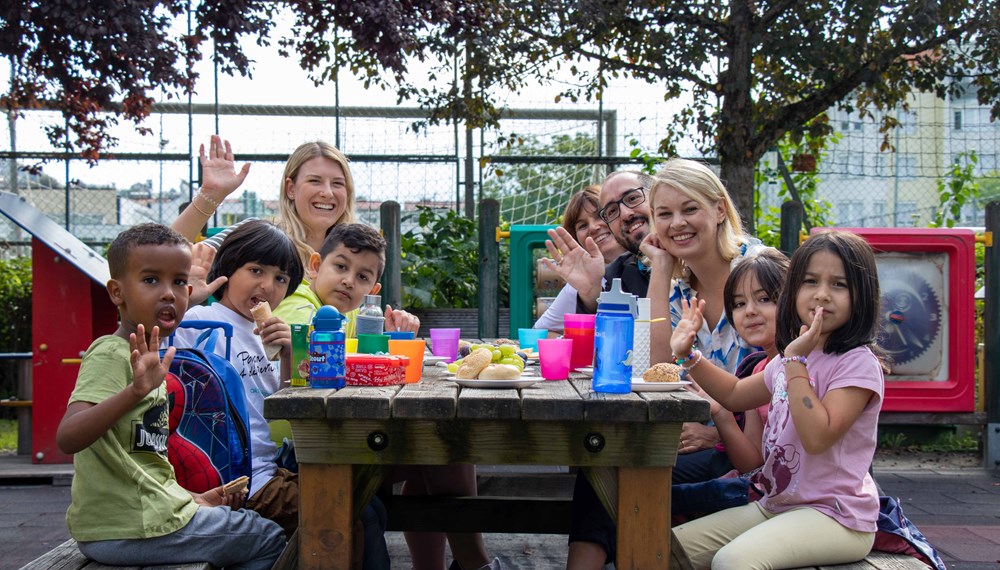 (v. l. ) Pädagogin Julia Untertroger, Nicola Köfler (Amt für Stadtplanung, Stadtentwicklung und Integration), Projektleiter Jugendrotkreuz Alexander Sulzenbacher-Schell und Stadträtin Elisabeth Mayr jausnen gemeinsam mit den Kindern.