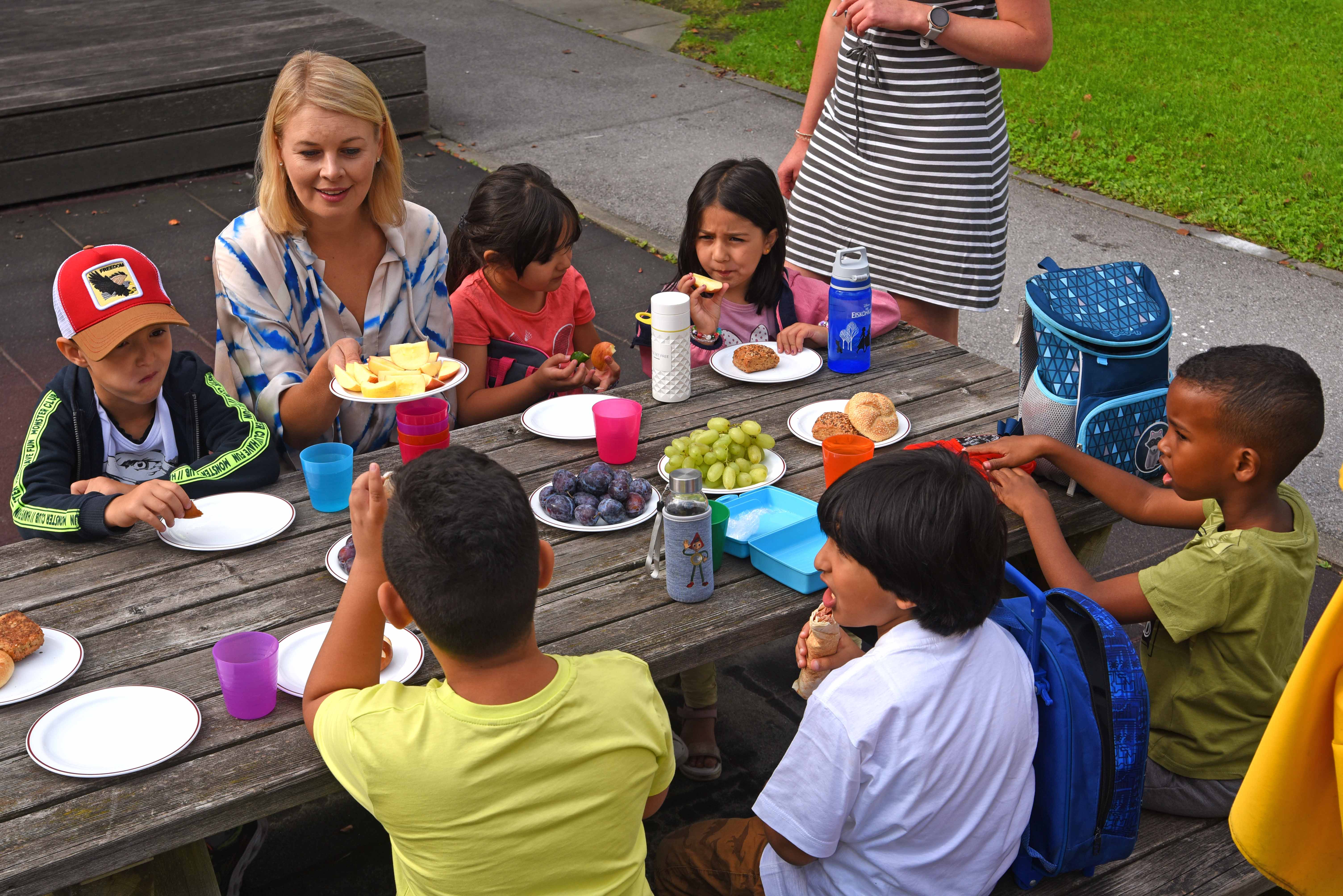 Stadrätin Mayr plaudert bei der gemeinsamen Jause mit den Kindern.