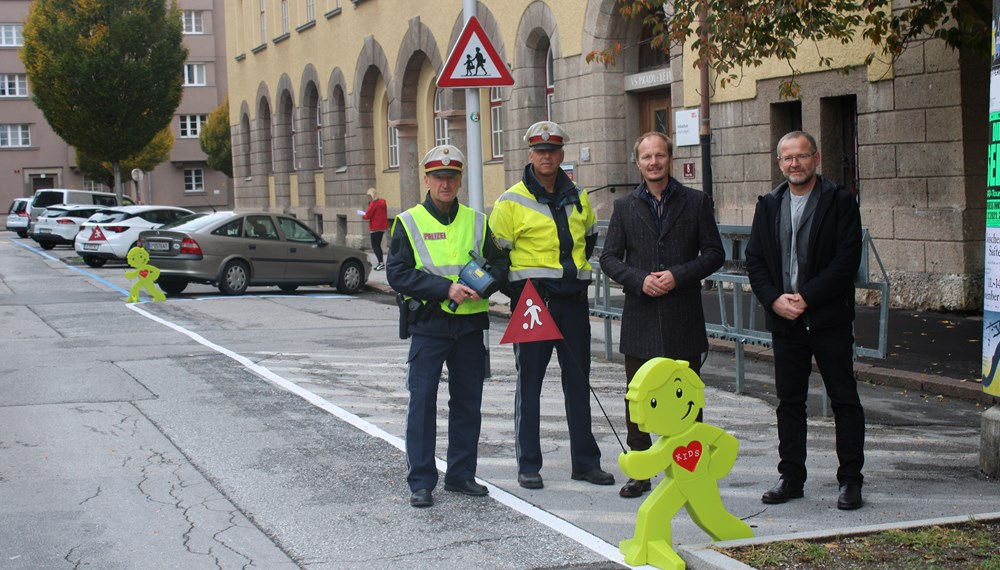 Vizebürgermeister Johannes Anzengruber, Amtsleiter Allgemeine Sicherheit, Klaus Feistmantl (r.), sowie zwei Polizisten der Verkehrsinspektion Wilten appellieren für mehr Aufmerksamkeit im Straßenverkehr. Mit den grün leuchtenden "StreetBuddies" sollen alle VerkehrsteilnehmerInnen frühzeitig darauf hingewiesen werden, dass sich wieder ab 12. September in den Bereichen der Aufsteller besonders viele Kinder auf den Weg in die Schule und den Kindergarten machen.