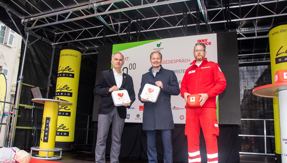 Vizebürgermeister Johannes Anzengruber, Michael Baubin, Vorsitzender des Österreichischen Rates für Wiederbelebung und Reanimations-Beauftragter für den RD des Landes Tirol (l.) sowie Matthias Stark, Leiter des Ausbildungszentrums beim Roten Kreuz Innsbruck (r.), machten beim Sicherheits- und Familienfest in der Innsbrucker Innenstadt auf die Wichtigkeit von Wiederbelebungsmaßnahmen mittels Defibrillator-Einsatz aufmerksam.