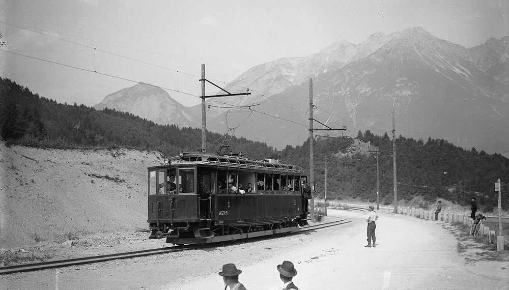 Triebwagen der Stubaitalbahn, rechts die Brennerstraße mit einigen Wanderern