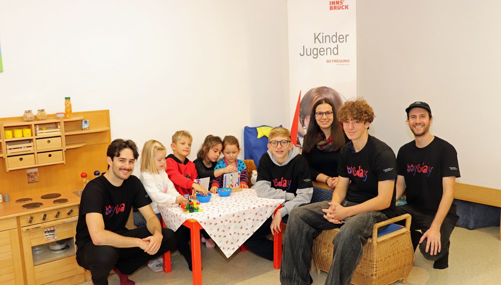 Zu Besuch im KG Sieglanger: Die beiden Boys’ Day-Teilnehmer Manuel und Manuel (2. und 4. v.r., Melanie Pichler (Amt Kinder, Jugend und Generationen), Julien Bartl und Albert Witting vom Verein „Mannsbilder” (1. v.l. und 1. v.r., Koordination Boys’ Day) und die Kindergartenkinder.