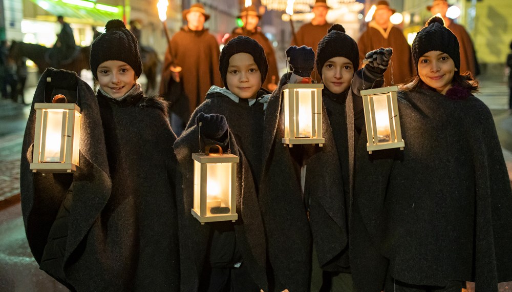 Das Christkind wird von einem Zug aus Hirten, Engeln und Schafen begleitet.