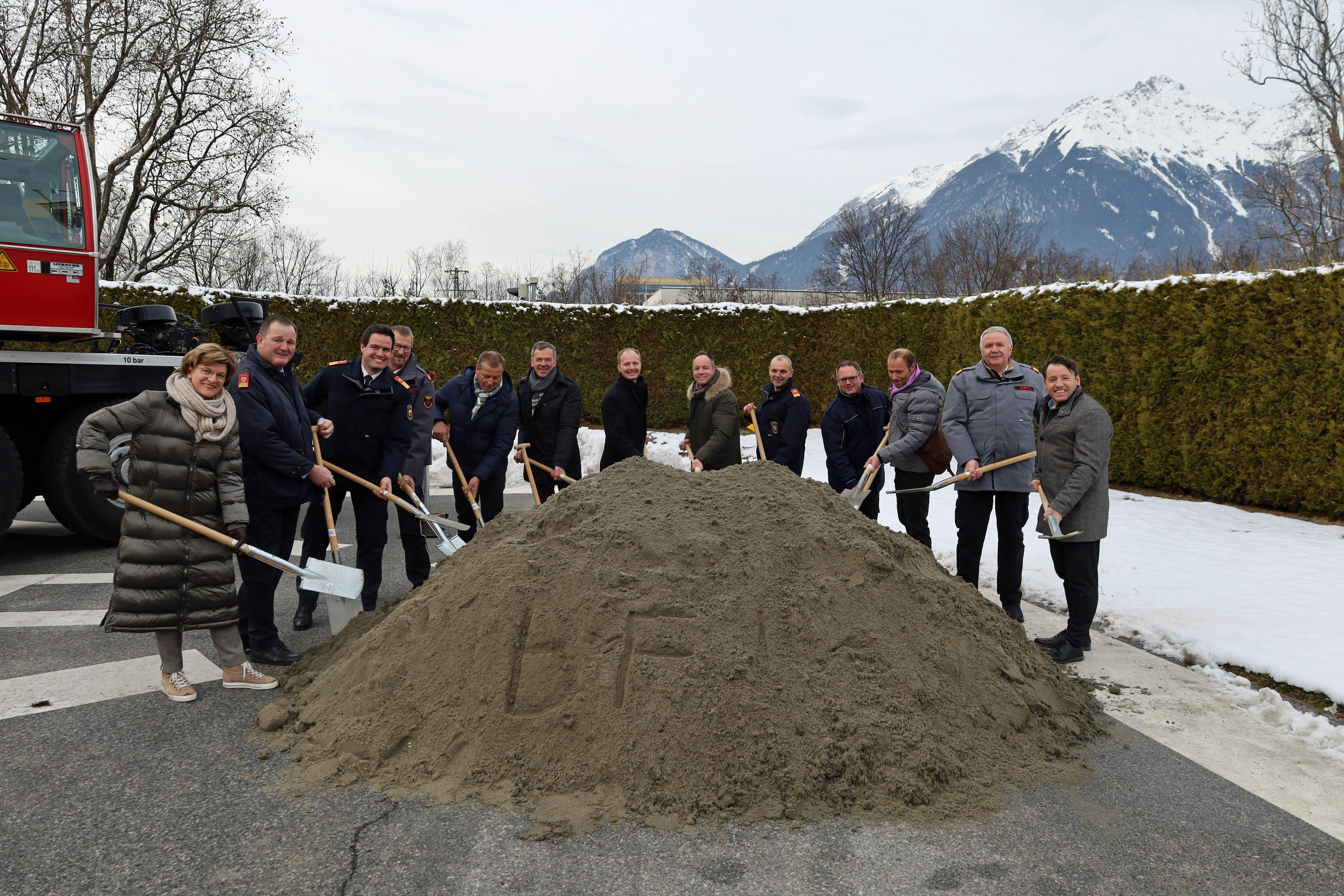 Bürgermeister Georg Willi (6.v.l.), Vizebürgermeister Markus Lassenberger (6.v.r), Vizebürgermeister Johannes Anzengruber (7.v.r.), Stadträtin Christine Oppitz-Plörer (l.), Gemeinderat Helmut Buchacher (5.v.l.), IIG-Geschäftsführer Franz Danler (r.), Branddirektor Helmut Hager (3.v.l.), Branddirektor-Stellvertreter Johann Zimmermann (2.v.l.), Landesfeuerwehrinspektor Alfons Gruber (2.v.r.) und weiteren Vertretern der Feuerwehr beim gemeinsamen Spatenstich.