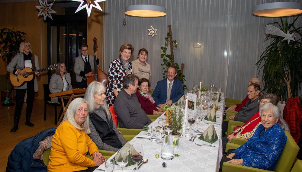 Stadträtin Christine Oppitz-Plörer (stehend, l.) Christine Kurz (Leitung ISD-SeniorInnenwohnen, stehend, r.) und Stefan Hetzenauer (ISD-Wohnanlagen Pradl und O-Dorf 3, r.) feierten mit den SeniorInnen im Wohnheim Tivoli. Auch für musikalische Unterhaltung war gesorgt.
