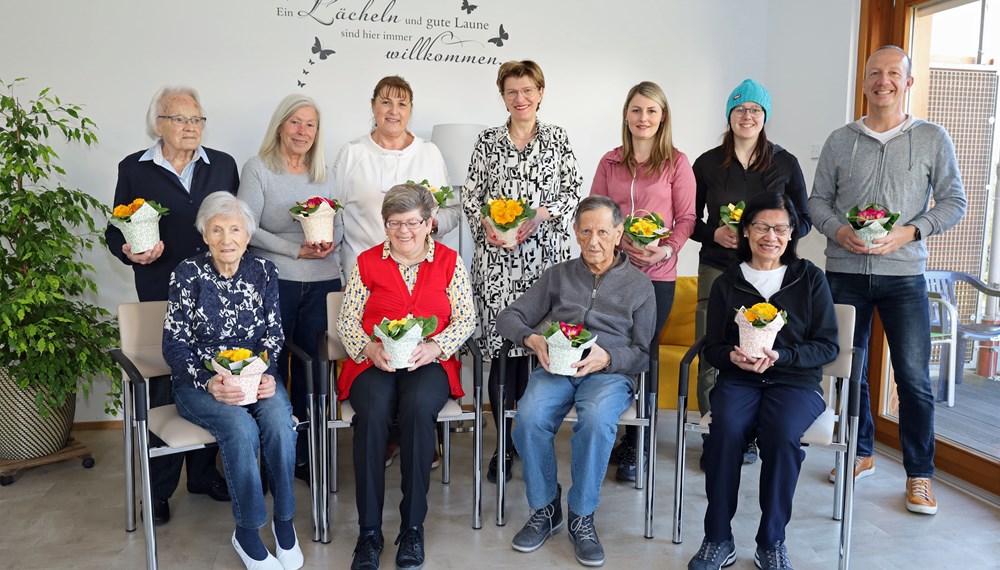 Stadträtin Christine Oppitz-Plörer (4.v.l., stehend) überreichte gemeinsam mit Christine Kurz (Leitung ISD-SeniorInnenwohnen, 3.v.l., stehend), Stefan Hetzenauer (ISD-Wohnanlage Pradl, r., stehend) sowie den Stadtgärtnerinnen Ramona Prinoth (3.v.r., stehend) und Stefanie Huetz (2.v.r., stehend) blumige Valentinsgrüße an BewohnerInnen der SeniorInnenwohnanlage Pradl.