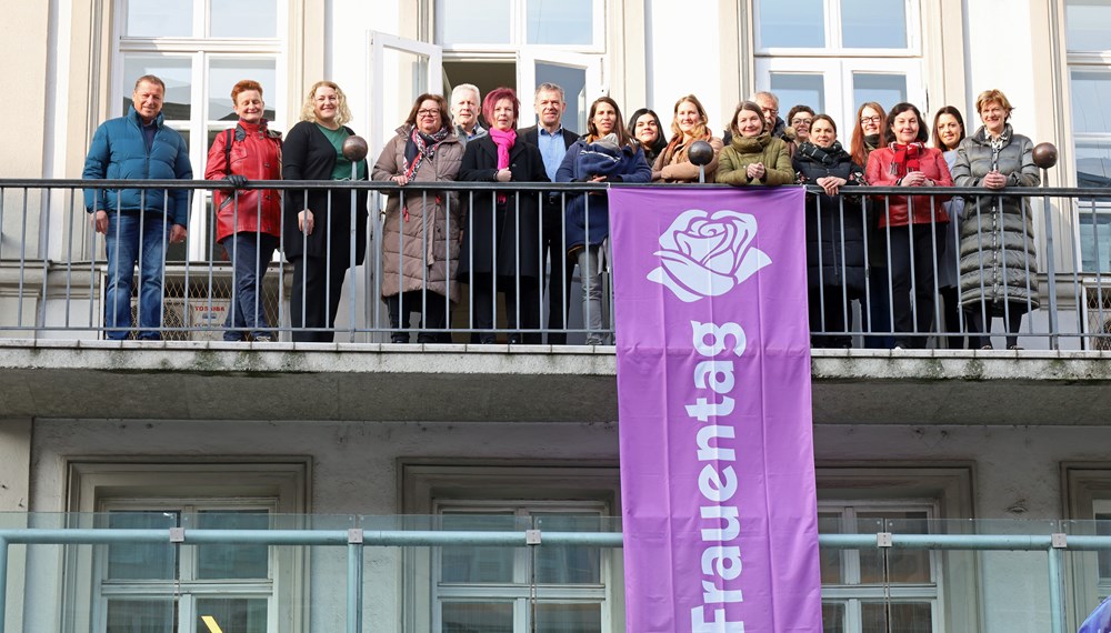 Bürgermeister Georg Willi (7. v. l.), Stadträtin Uschi Schwarzl (8. v. r.), Stadträtin Christine Oppitz-Plörer (r.), VertreterInnen des Gemeinderates sowie verschiedener Frauenorganisationen hissten gemeinsam mit Referatsleiterin Uschi Klee (6. v. l.) die Fahne am Innsbrucker Rathaus.