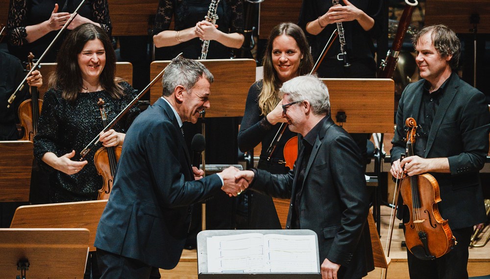 Bürgermeister Georg Willi (l.) gratuliert Dirigent Gerhard Sammer zum Erhalt des Ehrenzeichens für Kunst und Kultur der Stadt Innsbruck.