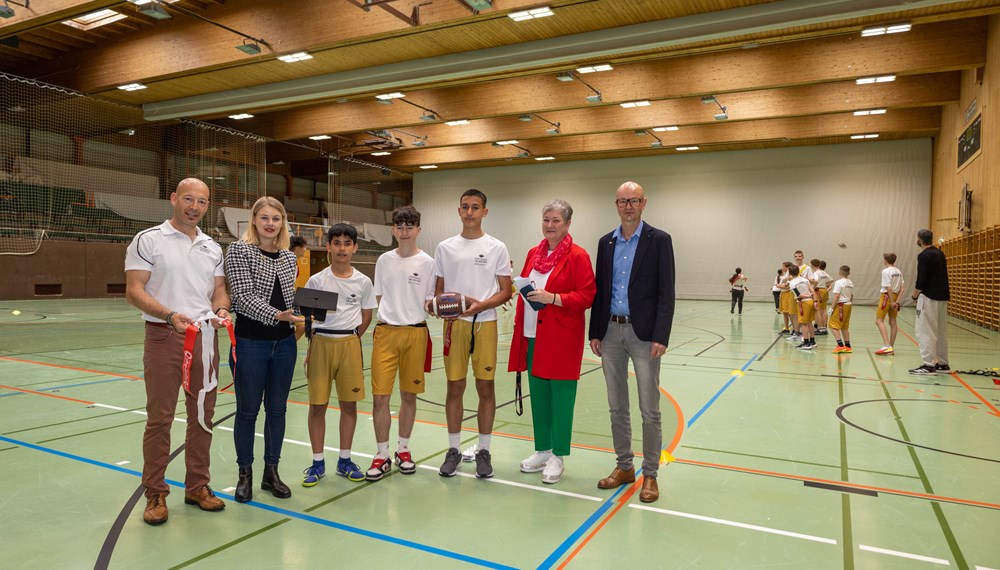 Akademie-Leiter Daniel Dieplinger, Stadträtin Elisabeth Mayr, Schuldirektorin Sabine Rainer und Amtsleiter Werner Leithmayer besuchten die Burschen Milad, Simon und Arslancan (v. l. n. r.) und ihre Klasse beim Football-Training.