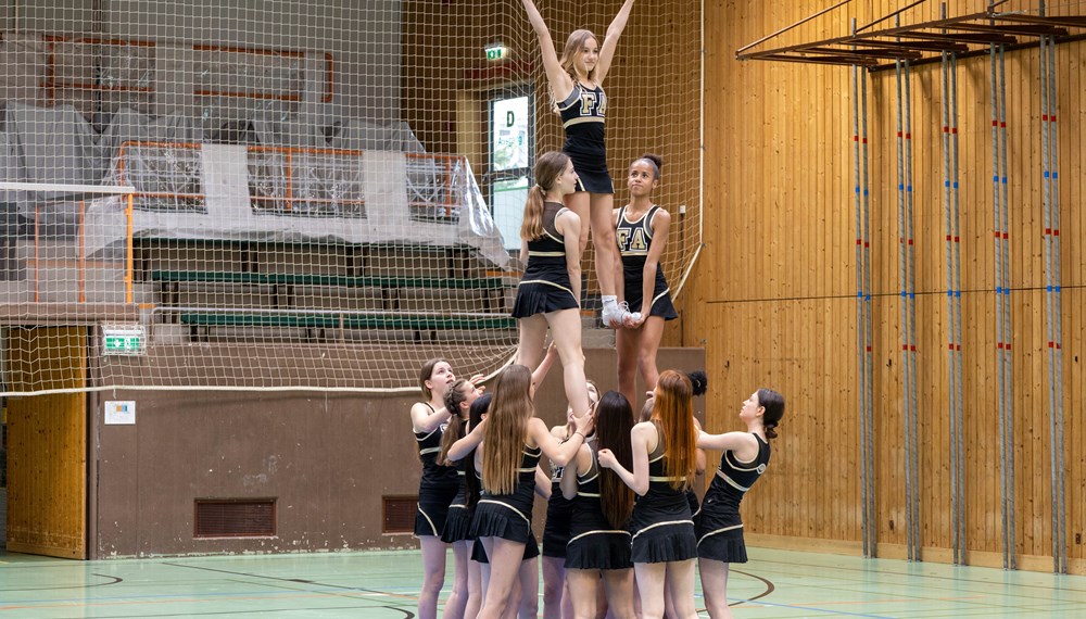 Die Cheerleaderinnen beim akrobatischen Probelauf für die anstehende Jubiläumsfeier.