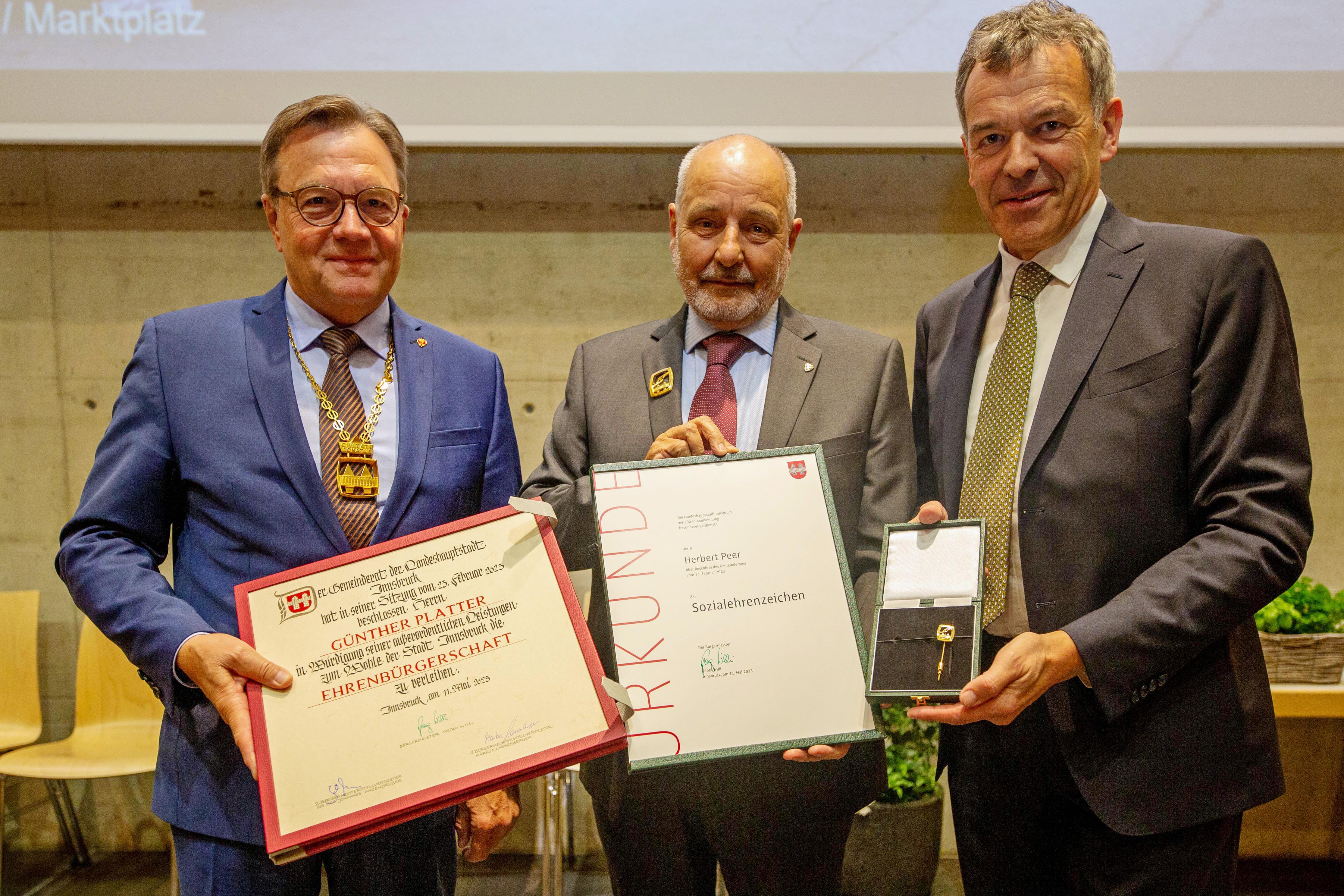 Ehrungstag am 11. Mai im Mehrzwecksaal im Olympischen Dorf: Landeshauptmann a.D. Günther Platter (l.) wurde von Bürgermeister Georg Willi (r.) die Ehrenbürgerschaft, Herbert Peer (Mitte) das Sozialehrenzeichen verliehen.