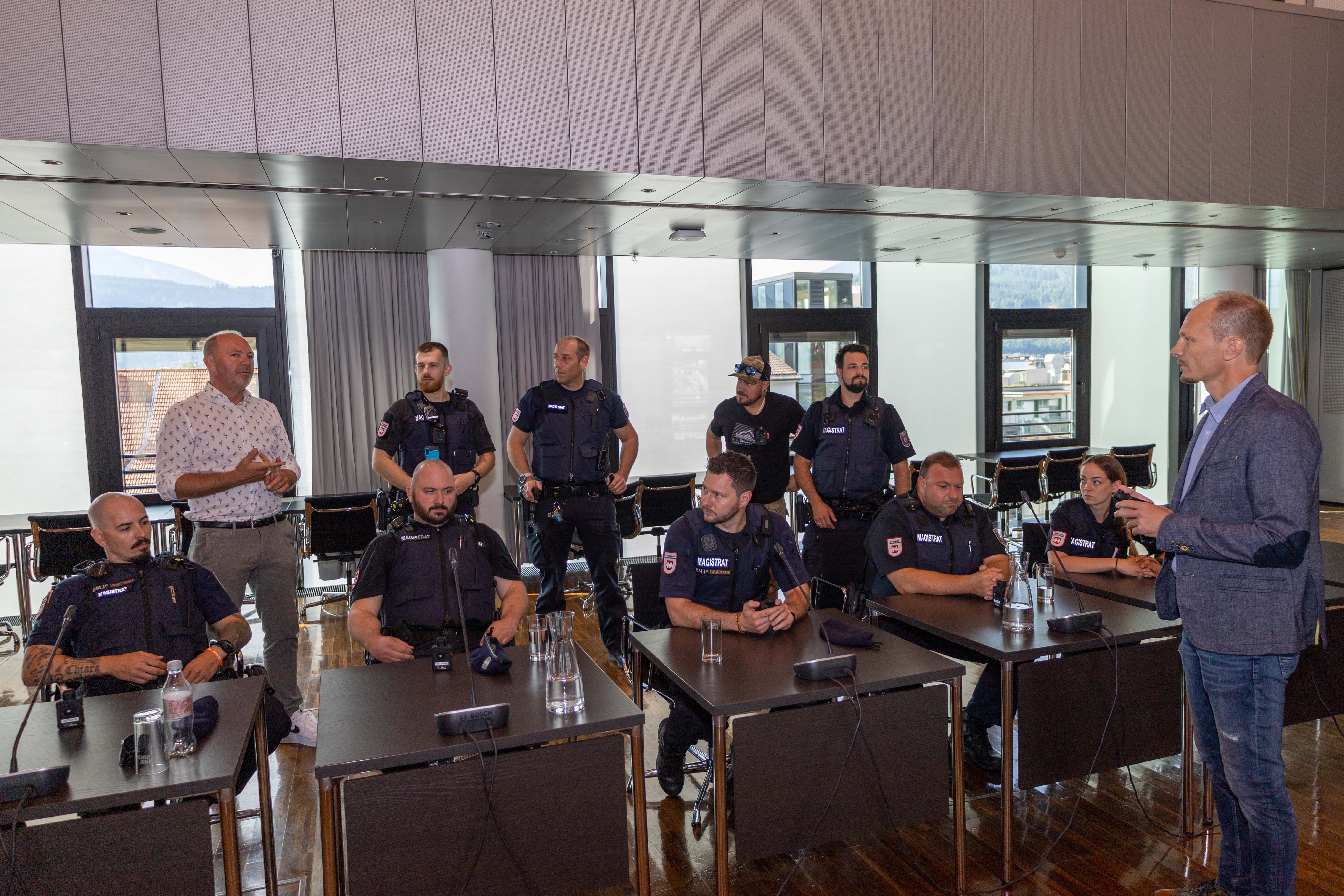 Vizebürgermeister Johannes Anzengruber im Austausch mit Thomas Koland (hinten links), zuständiger Referatsleiter für Öffentliche Ordnung, während der Bodycam-Einschulung der MÜG-Bediensteten im Innsbrucker Rathaus.