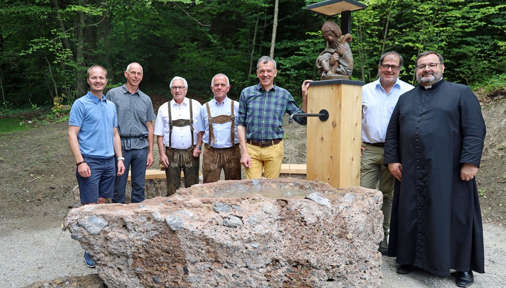 Bürgermeister Georg Willi (3.v.r), Vizebürgermeister Johannes Anzengruber (l.), Amtsvorstand Andreas Wildauer (Wald und Natur, 2.v.r.) Pfarrer Malek Ciesielski (Pfarre Hötting, r.), Pfarrökonom Josef Madersbacher (Pfarre Hötting, 4.v.l.), Siegfried Ploner (ploner.consult, 3.v.l.) und Forstunternehmer Manfred Leiter (2.v.l.) freuen sich über den neu errichteten Trinkwasserbrunnen am Höttinger Bild.