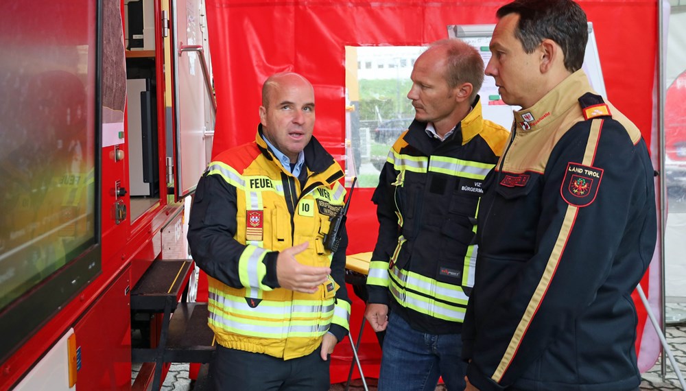 Vizebürgermeister Johannes Anzengruber (m.), Einsatzleiter Marcus Wimmer (l.) und der designierte Tiroler Landesfeuerwehrinspektor René Staudacher (r.) besprechen die Lage bei der Einsatzleitung in der Standschützenkaserne.