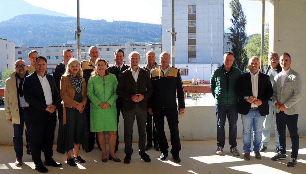 Vizebürgermeister Markus Lassenberger (r.), der ressortzuständige Vizebürgermeister Johannes Anzengruber (7.v.r.), Stadträtin Elisabeth Mayr (5.v.l.), die Gemeinderäte Helmut Buchacher (4.v.r.), Lucas Krackl (3.v.r.) und Gerhard Fritz (2.v.r) freuen sich gemeinsam mit IIG-Geschäftsführer Franz Danler (3.v.l.), Branddirektor Helmut Hager (8.v.l.), Branddirektor-Stellvertreter Johann Zimmermann (4.v.l.), Bezirks-Feuerwehrkommandant Gerhard Mayregger (5.v.r), Tirols Landesfeuerwehrinspektor Alfons Gruber (6.v.l.), dem designierten Landesfeuerwehrinspektor René Staudacher (2.v.l.), Rotes-Kreuz-Innsbruck-Geschäftsführerin Alexandra Tanda (6.v.l.) sowie Vertretern der Baufirma Bodner über den Baufortschritt an der Hauptfeuerwache.