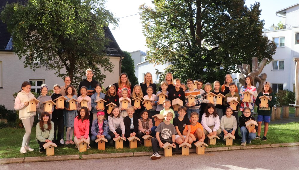 Ein ökologischer Beitrag: Die Kinder der Volksschule Hötting freuten sich über die Vogelnistkästen, gemeinsam mit Stadträtin Elisabeth Mayr (hintere Reihe, 2.v.r.), Projektleiterin Isabella Prossliner (hintere Reihe, 1.v.r.) und Direktorin Dagmar Klingler (hintere Reihe, 3.v.l.).