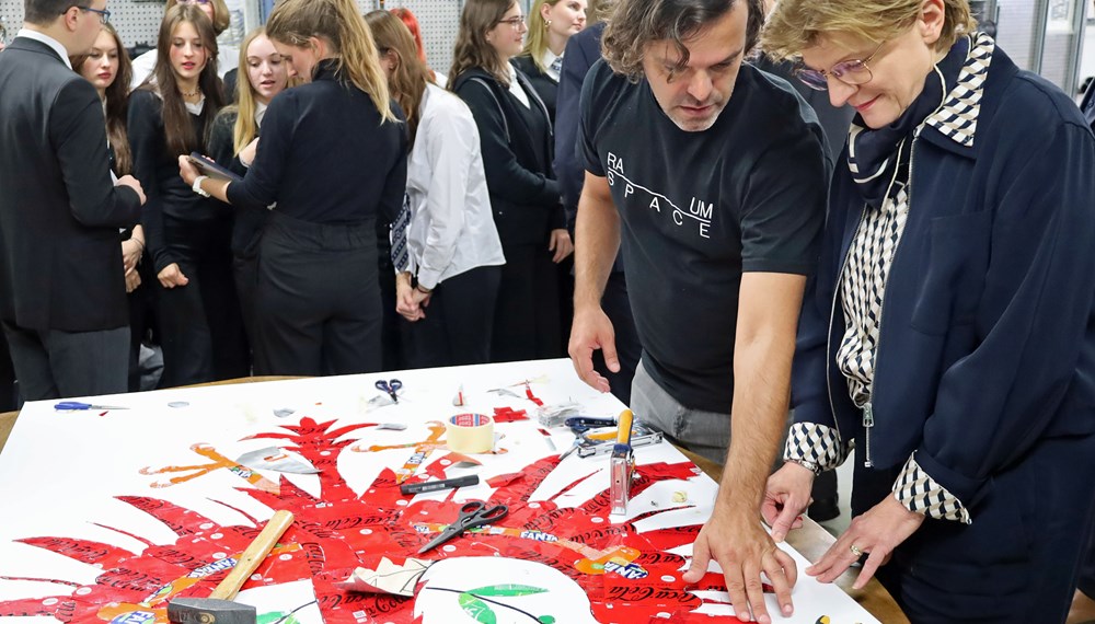 Aus alten Getränkedosen wird der Tiroler Adler: Preisträger José Rodrigues (2.v.r.) und Stadträtin Christine Oppitz-Plörer (r.) bei der Begutachtung des Upcycling-Kunstwerks.