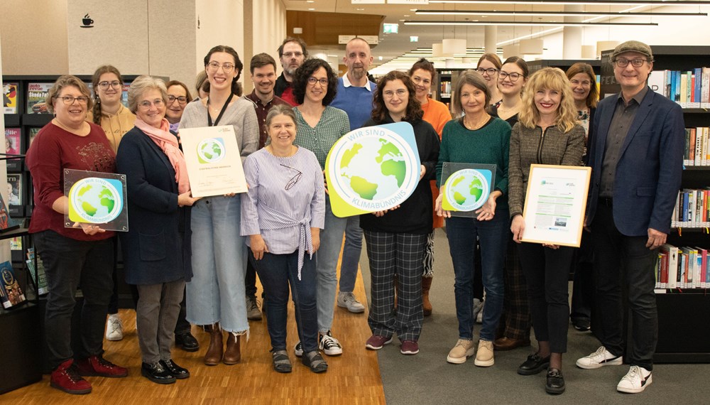 Nachhaltigkeit liegt dem Team der Stadtbibliothek Innsbruck am Herzen: Im Bild mit Stadträtin Uschi Schwarzl (vorne, 3. v.r.), Kulturamtsleiterin Isabelle Brandauer (vorne, 2. v.r.) und Andrä Stigger (GF Klimabündnis Tirol, 1. v.r.).