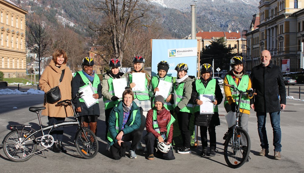 Bei der Übergabe der Radkurs-Teilnahmezertifikate vor der Messe Innsbruck: Nicola Köfler (l., Integrationsstelle Stadt Innsbruck), Städtischer Fuß- und Radkoordinator Christian Schoder (r.) Simone Profus (Leitung Radkurse Klimabündnis Tirol, vorne links) und die Radkurs-Trainerin Isabella (vorne rechts) mit den Teilnehmerinnen.