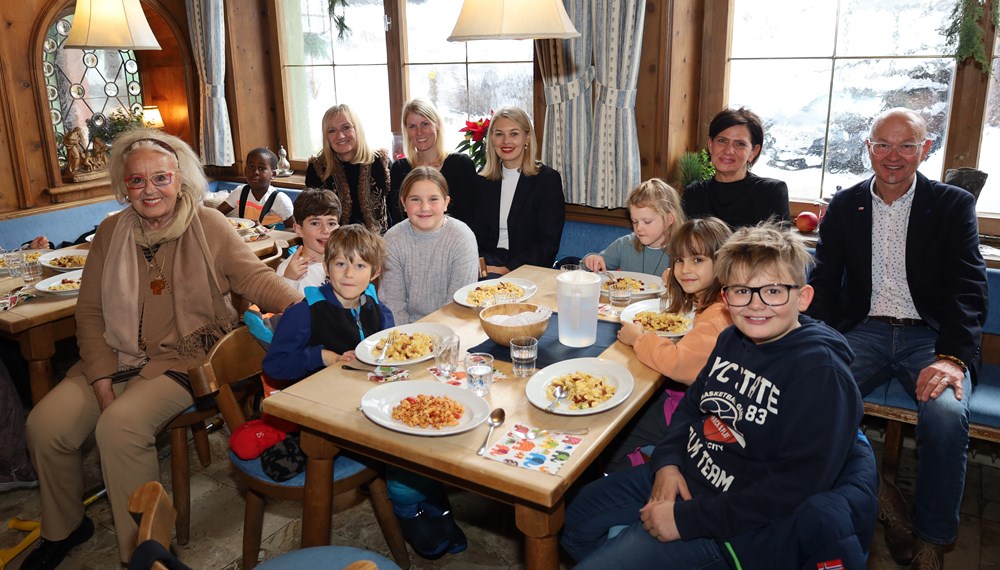 Stadträtin Elisabeth Mayr (7.v.r.) und Amtsvorstand Werner Leithmayer (r.) freuen sich mit den Volksschulkindern, den Lehrerpersonen und dem Ägidihof-Team über den Mittagstisch für die Tagesbetreuung der VS Igls-Vill.