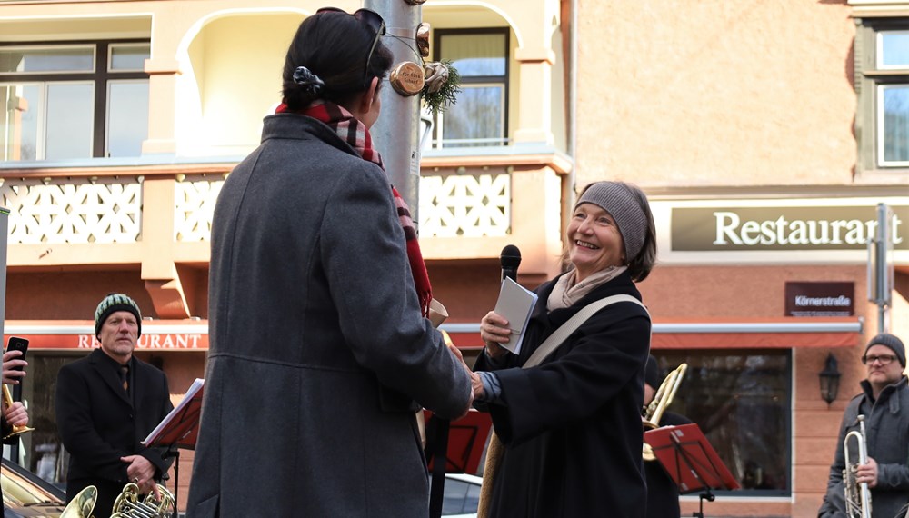 Kulturstadträtin Uschi Schwarzl (r.) enthüllt gemeinsam mit Kulturausschuss-Vorsitzender Irene Heisz (l.) die neuen Zeitpunkte in der Defreggerstraße.