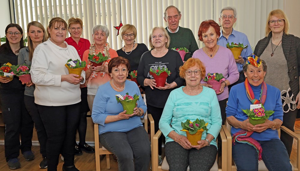 Stadträtin Christine Oppitz-Plörer (4.v.l., stehend) überreichte gemeinsam mit Christine Kurz (Leitung ISD-SeniorInnenwohnen, 3.v.l., stehend), Verena Plattner (ISD-Wohnanlage Igls, r., stehend) sowie den Stadtgärtnerinnen Ramona Prinoth (2.v.l., stehend) und Stefanie Huetz (l., stehend) blumige Valentinsgrüße an BewohnerInnen der SeniorInnenwohnanlage Igls.