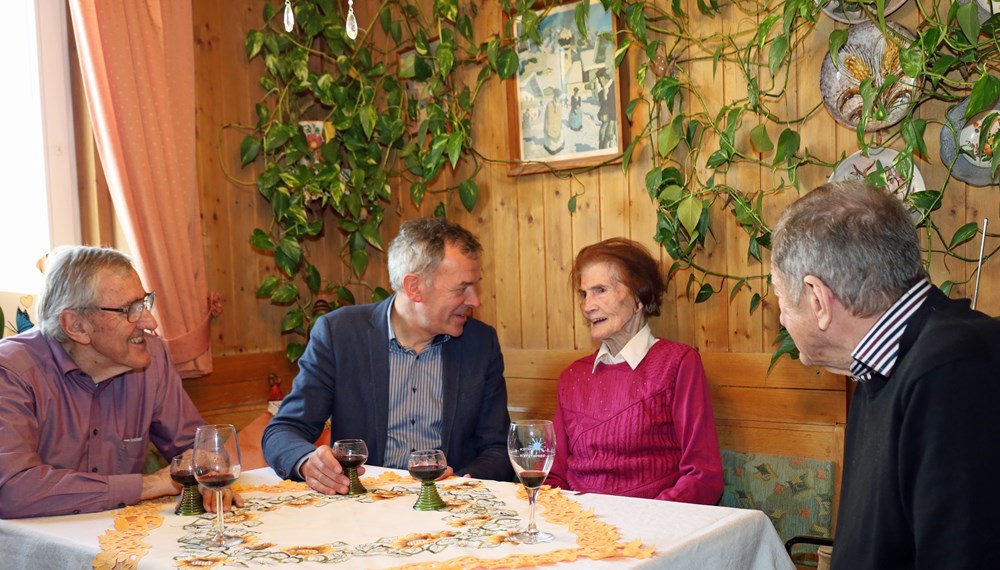 Maria Weger (2.v.r.) erzählt Bürgermeister Georg Willi (2.v.l.) bei der Feier im engen Familien- und Freundeskreis von ihrem Leben.